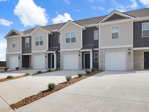 A row of modern houses with garages and driveways.