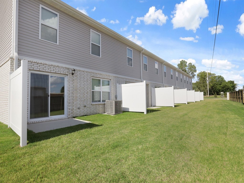 A line of houses with white garages and brick walls.