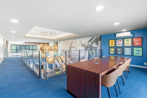 A conference room with a long table and chairs, a blue carpet, and a wall with a map of the world.