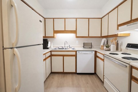 A kitchen with wooden cabinets and a white fridge.