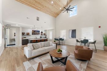 A living room with a white couch and brown chairs.