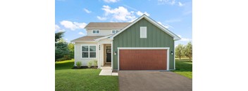 A house with a green garage door and a brown roof.