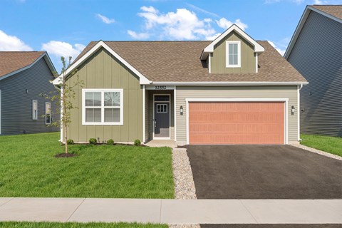 A house with a brown garage door and a grey roof.