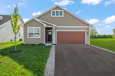 A house with a brown garage door and a driveway.