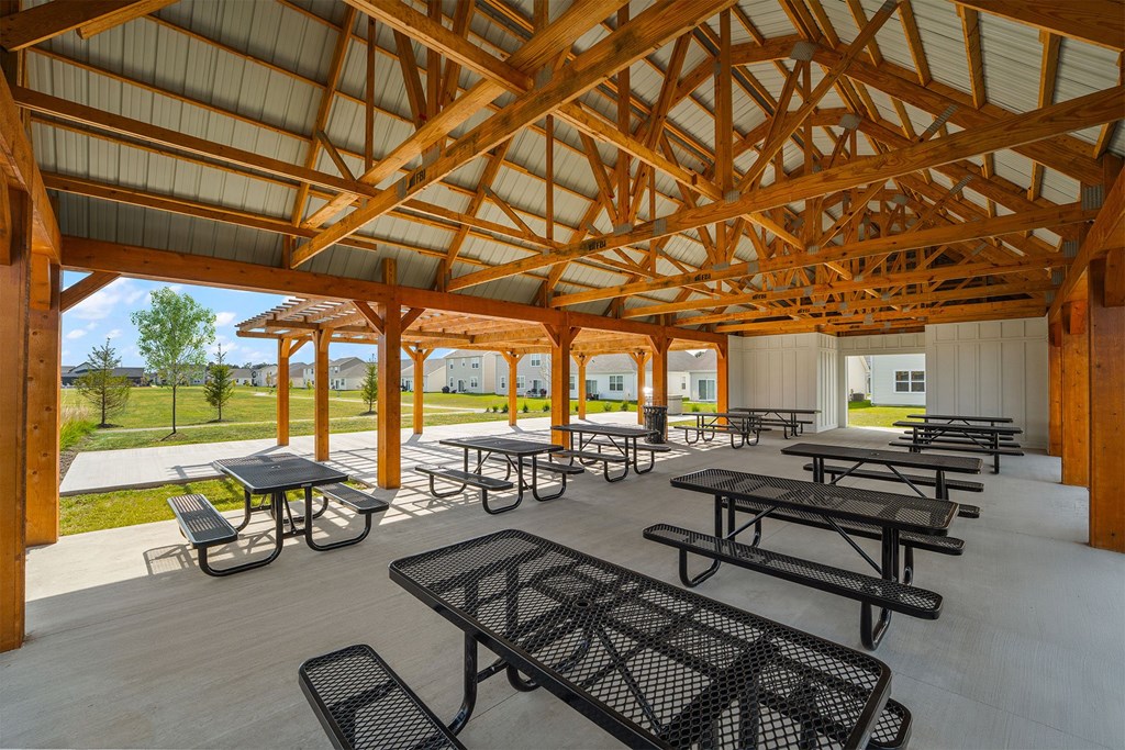 A wooden pavilion with tables and benches.