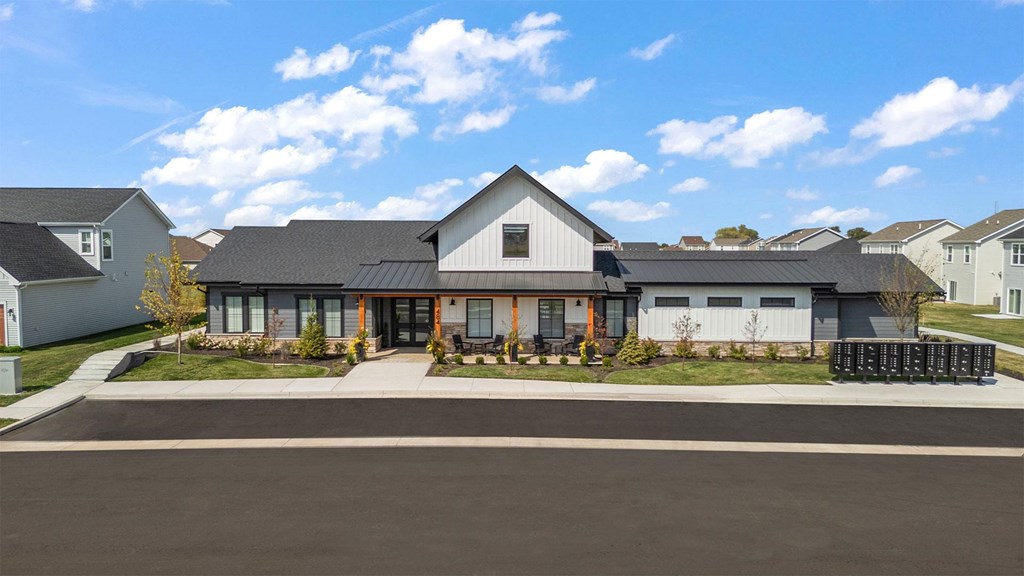 A modern building with a grey roof and a white entrance.