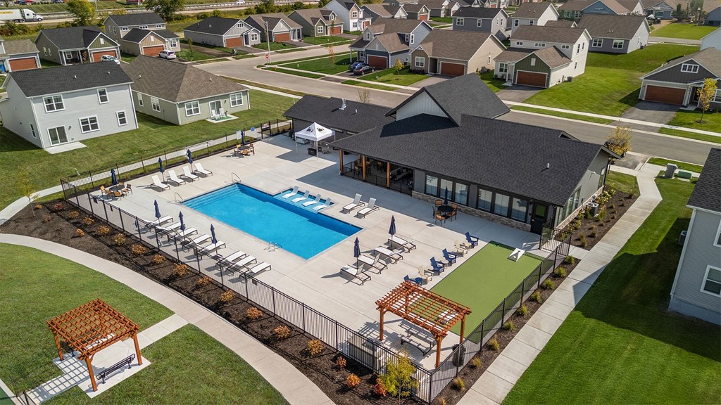 A large outdoor swimming pool surrounded by a deck and lounge chairs.