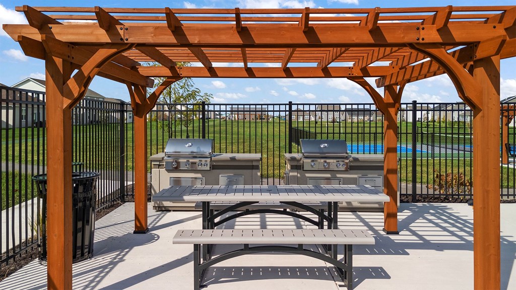 A wooden pergola with a picnic table underneath it.
