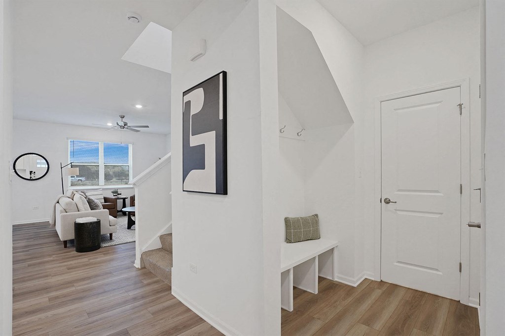 A living room with a couch, a table, a painting, and a window.