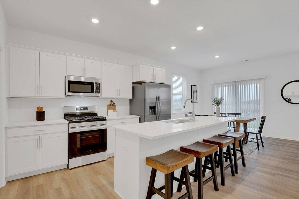 A modern kitchen with white cabinets and a wooden island.