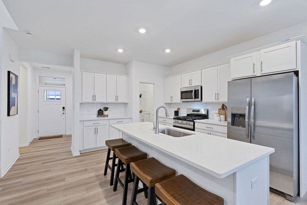 A modern kitchen with white cabinets and stainless steel appliances.