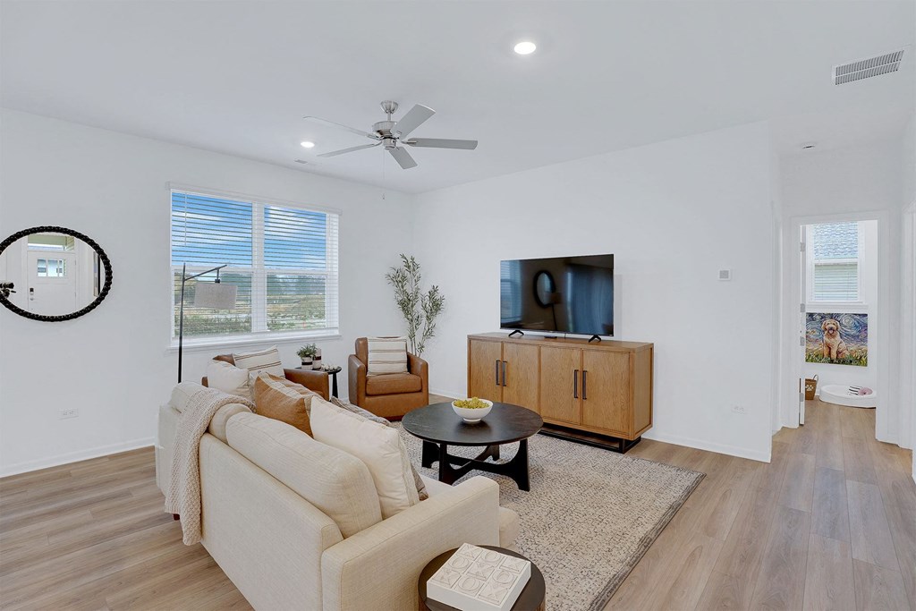A living room with a couch, a coffee table, and a television.