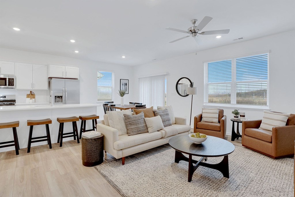 A living room with a white couch, a coffee table, and a ceiling fan.
