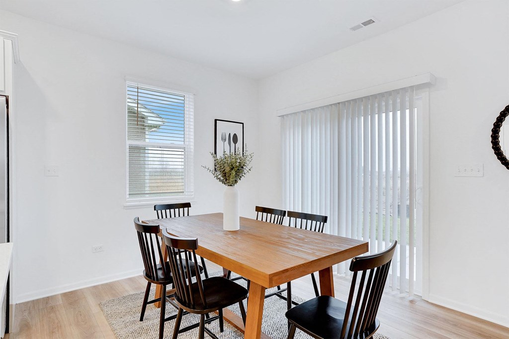 A dining room with a wooden table and chairs.