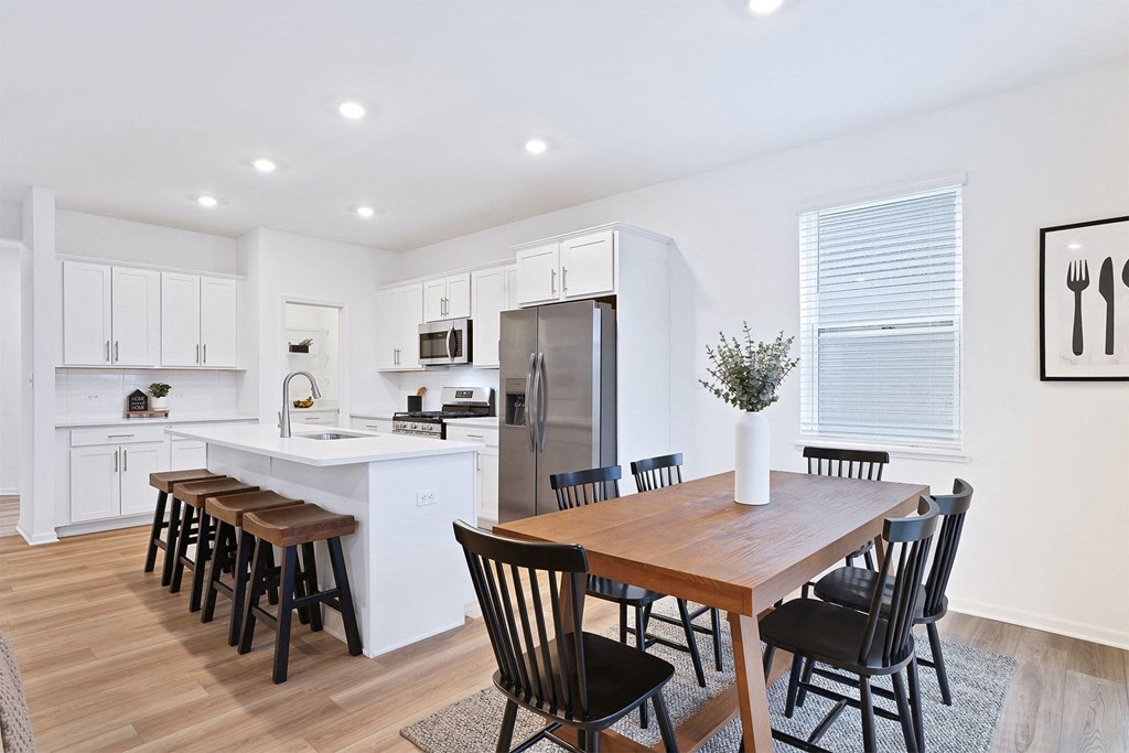 A modern kitchen with a dining table and chairs.