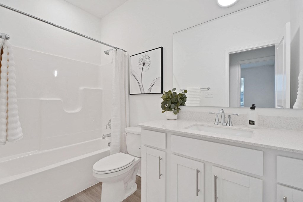 A white bathroom with a toilet, sink, and bathtub.