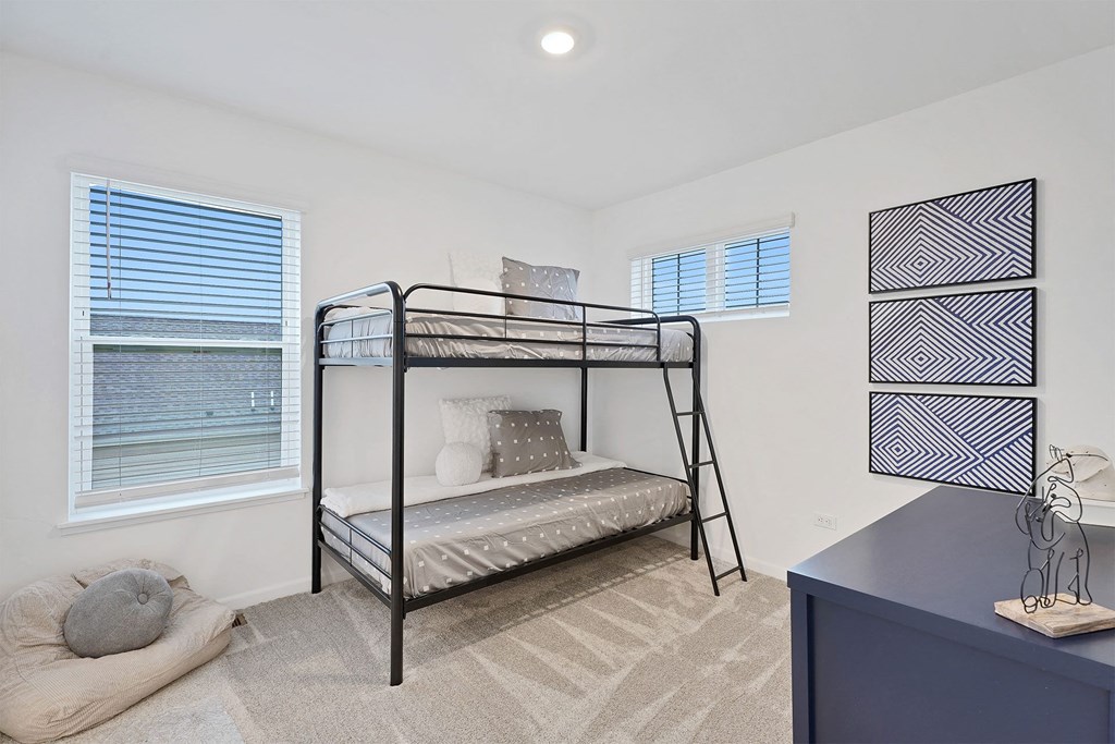 A bedroom with a bunk bed and a blue dresser.