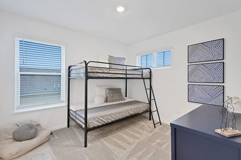 A bedroom with a bunk bed and a blue dresser.