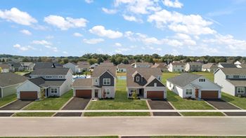 A row of houses with driveways in front of them.