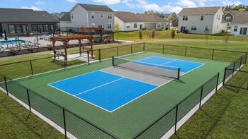 A tennis court with a blue surface and a black fence.