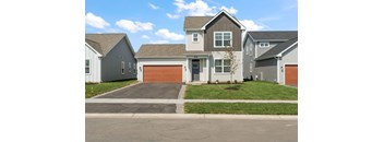 A house with a grey roof and a brown garage door.