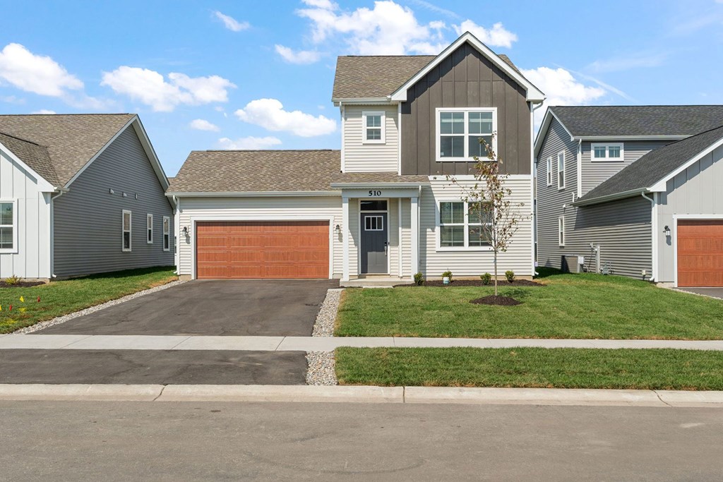 A house with a grey roof and a brown garage door.