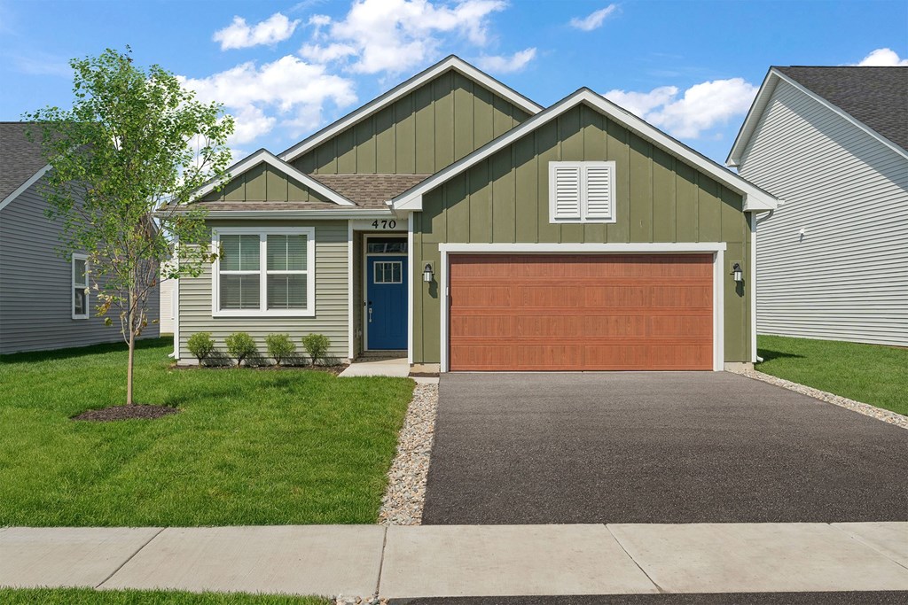 A house with a garage door and a driveway.