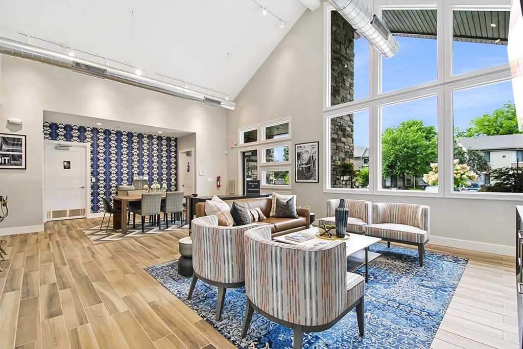 A living room with a striped couch and a blue rug.