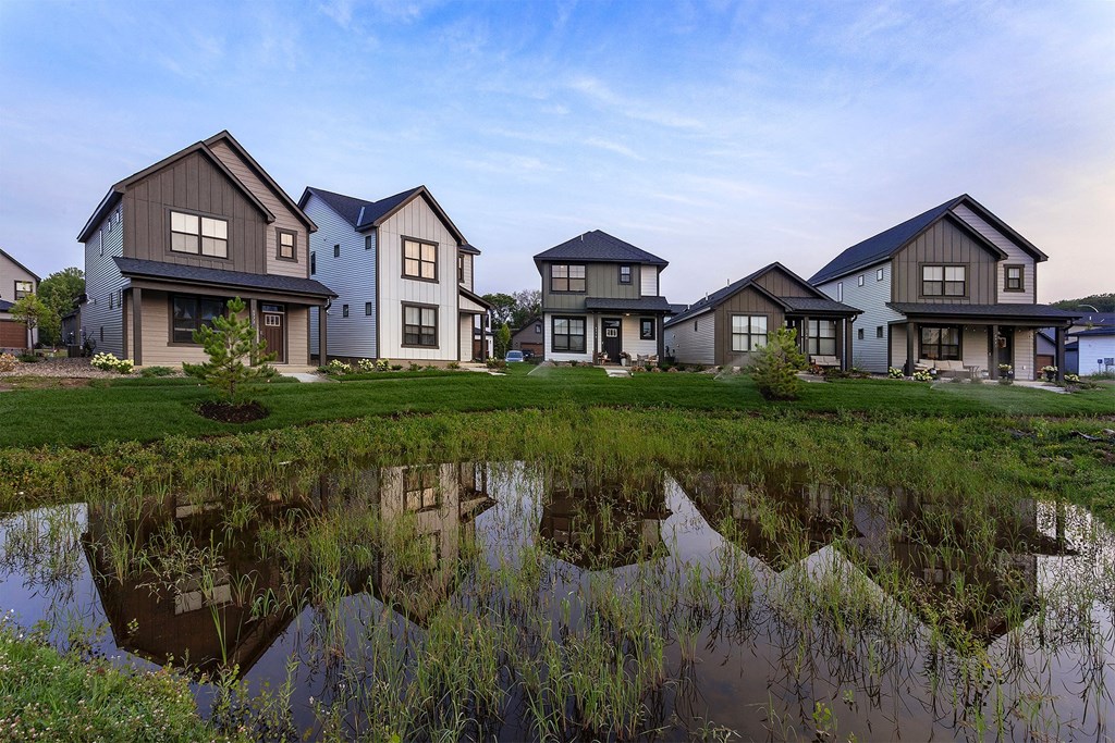 a group of houses reflected in a puddle of water