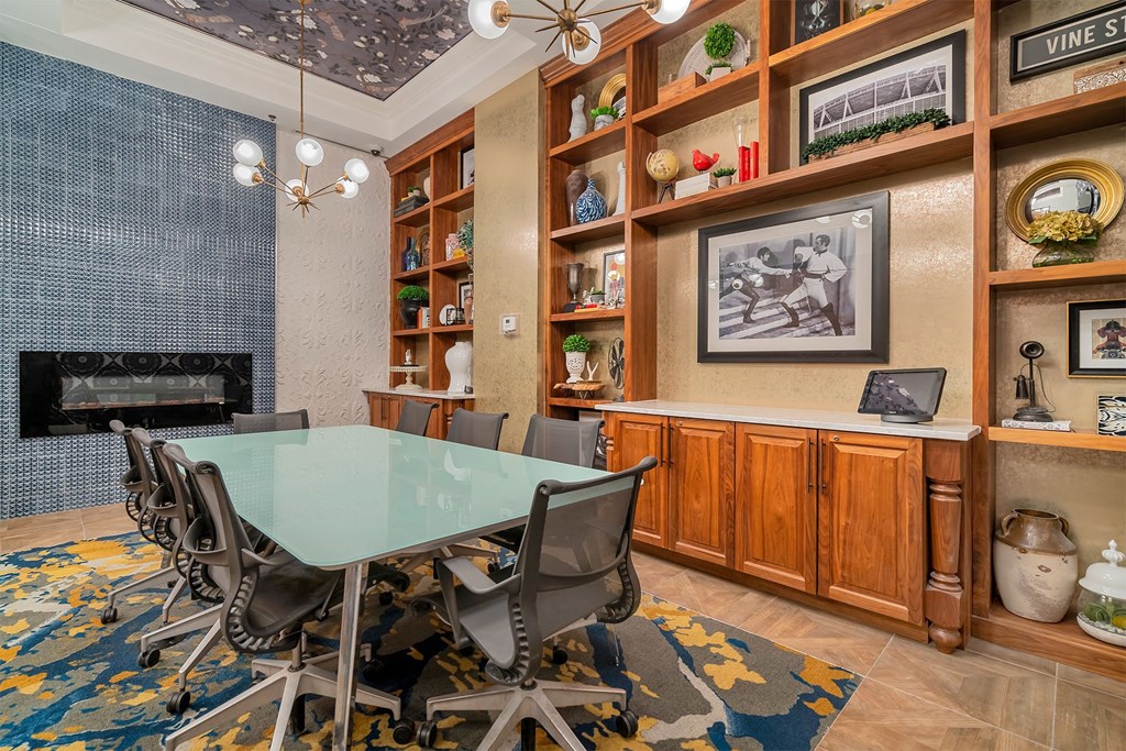 A conference room with a glass table surrounded by chairs.