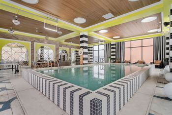A large indoor swimming pool with a striped tile border.