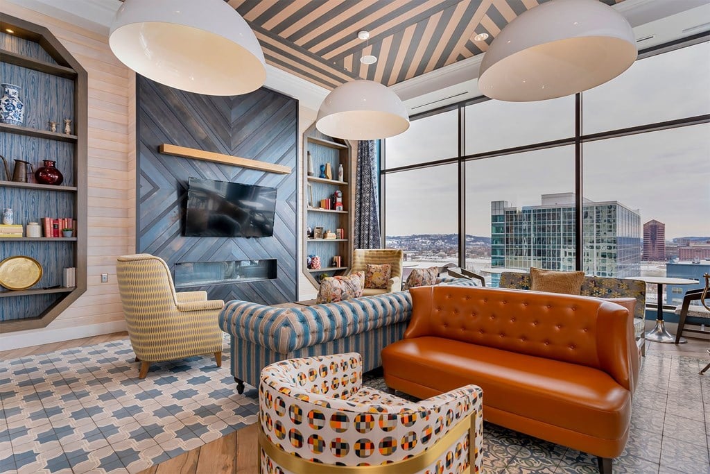 A living room with a fireplace and a view of the city.