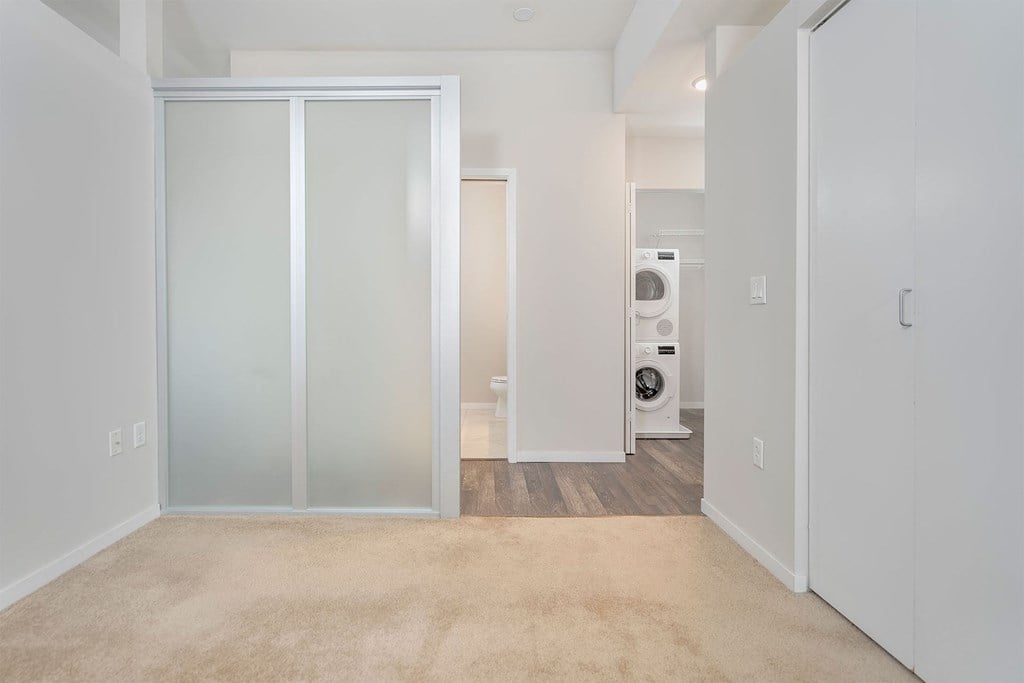 A room with a glass door and a washing machine in it.