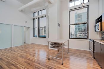 A kitchen with a table and a window overlooking a city.