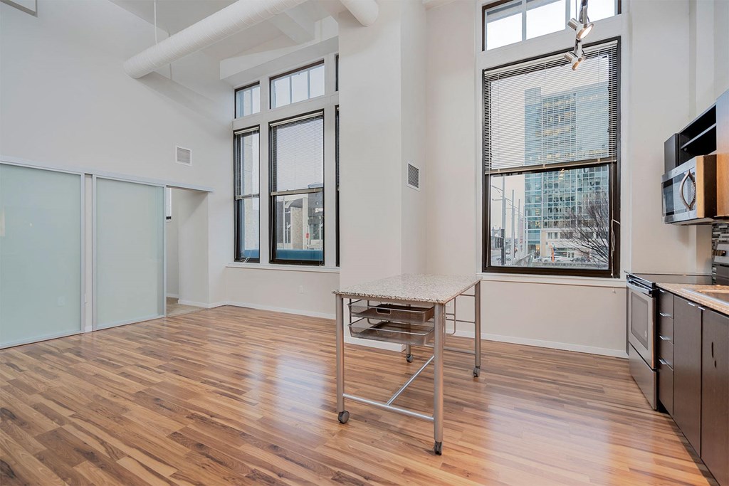 A kitchen with a table and a window overlooking a city.