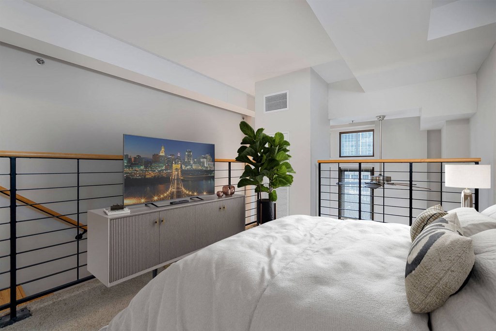 A bedroom with a bed, a cabinet, and a painting on the wall.