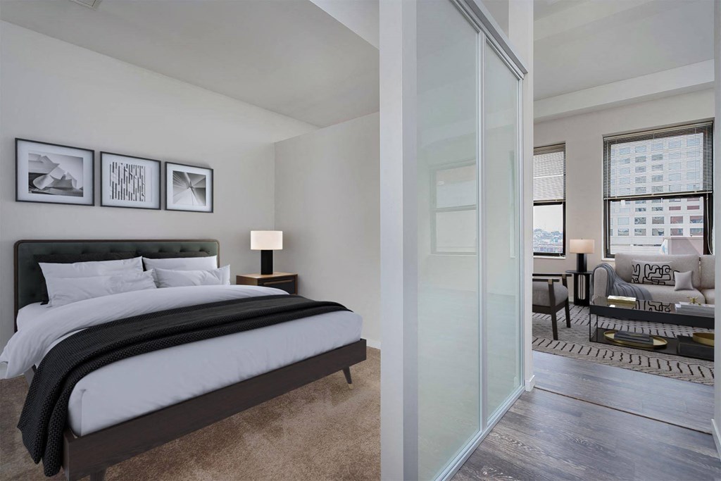 A bedroom with a large bed and a couch in the background.