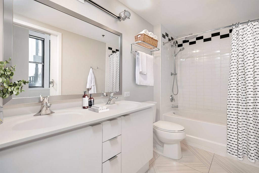 A white bathroom with a toilet, sink, and shower.