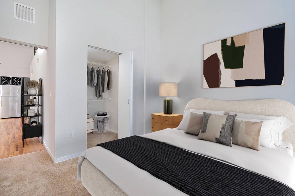 A bedroom with a large bed and a painting on the wall.