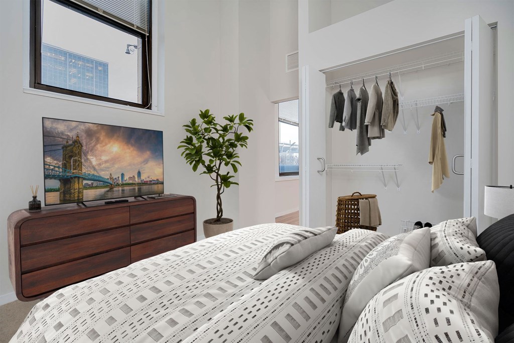 A bedroom with a large bed and a painting on the wall.