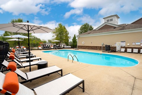 outdoor pool with lounge chairs and umbrellas