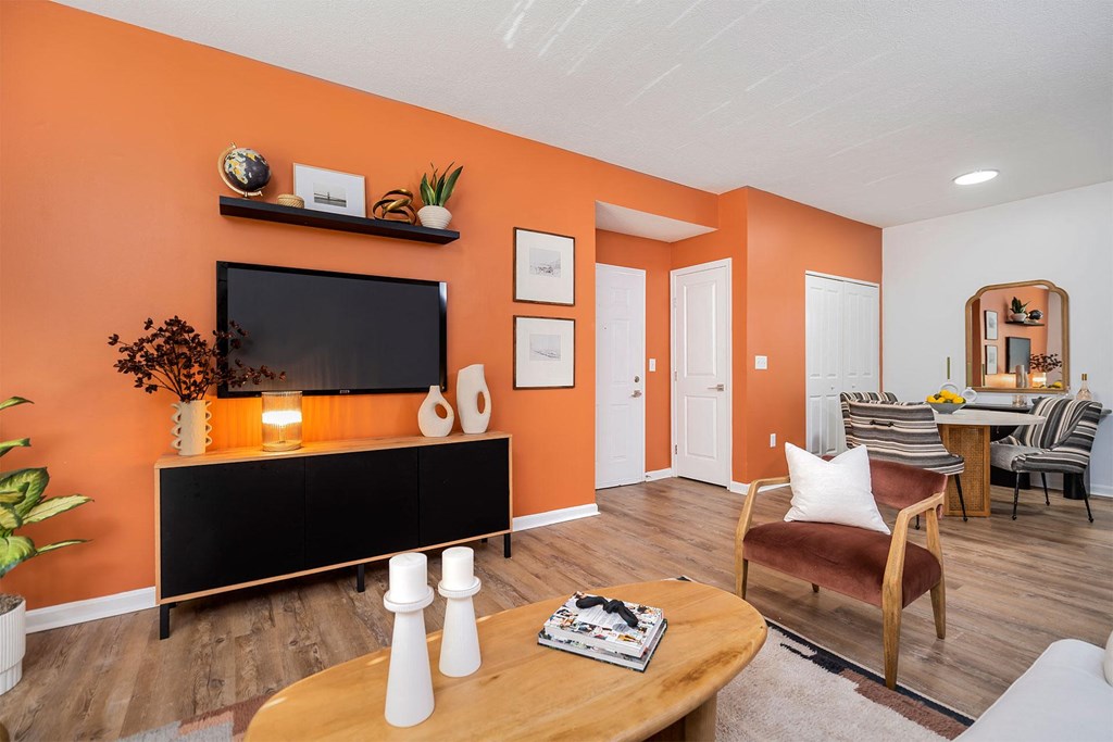 a living room with an orange wall and a television