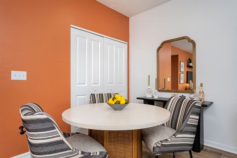 a dining room with two chairs and a table with a bowl of fruit