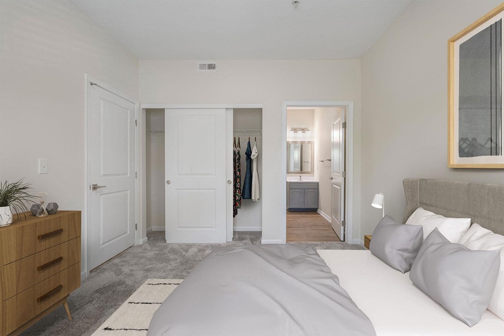 a bedroom with a large bed and a closet     and a bathroom