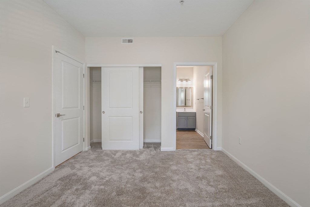 a bedroom with a carpeted floor and white doors
