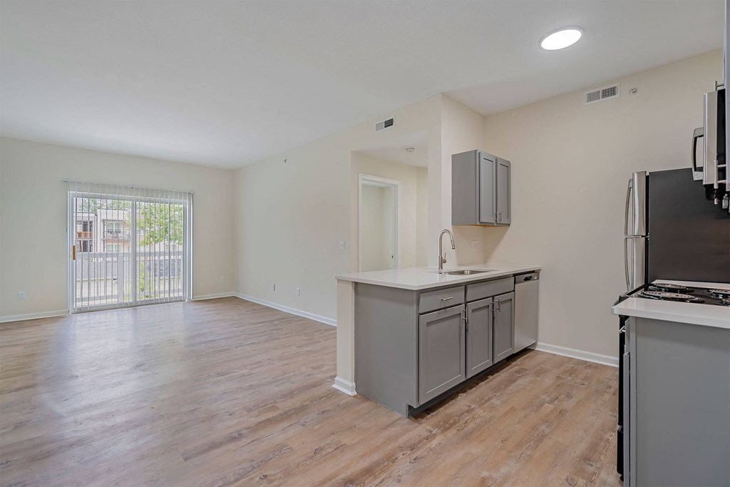 an empty kitchen and living room with a door to a patio