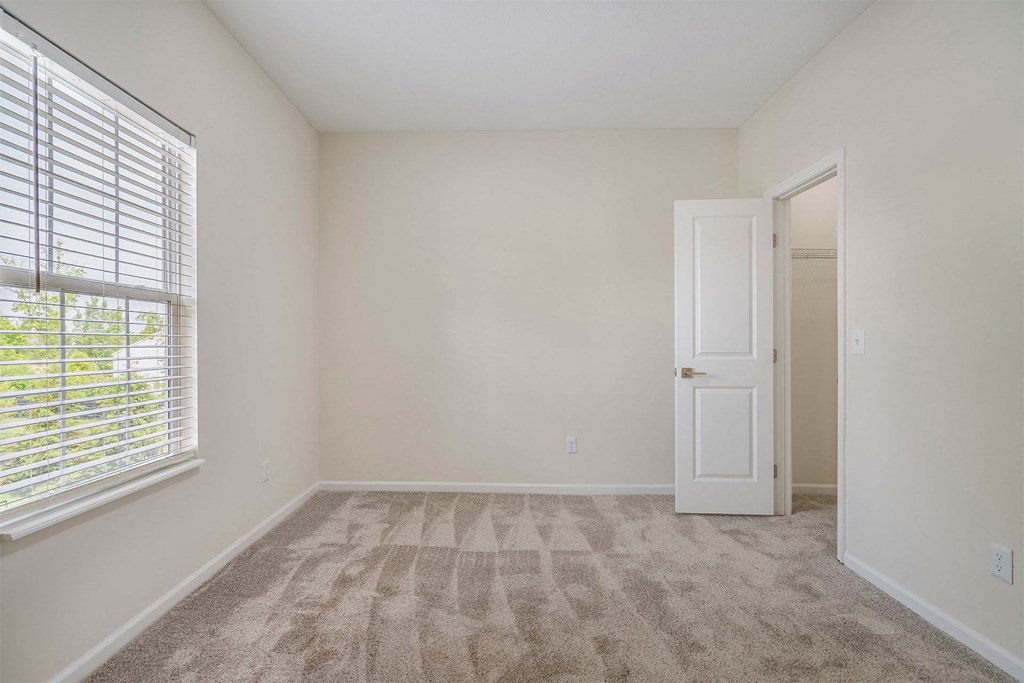 an empty room with a window and a door