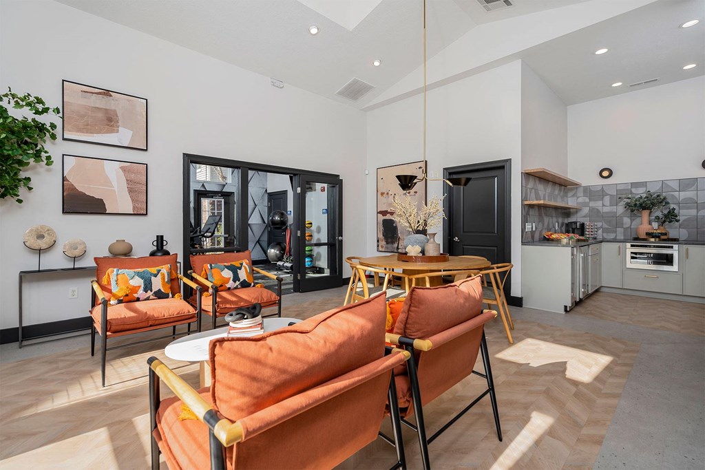 a living room with orange chairs and a table