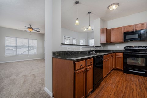 A kitchen with wooden cabinets and black countertops.