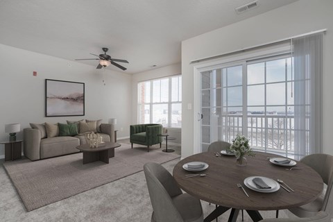 A living room with a brown couch, a coffee table, and a dining table set for four.